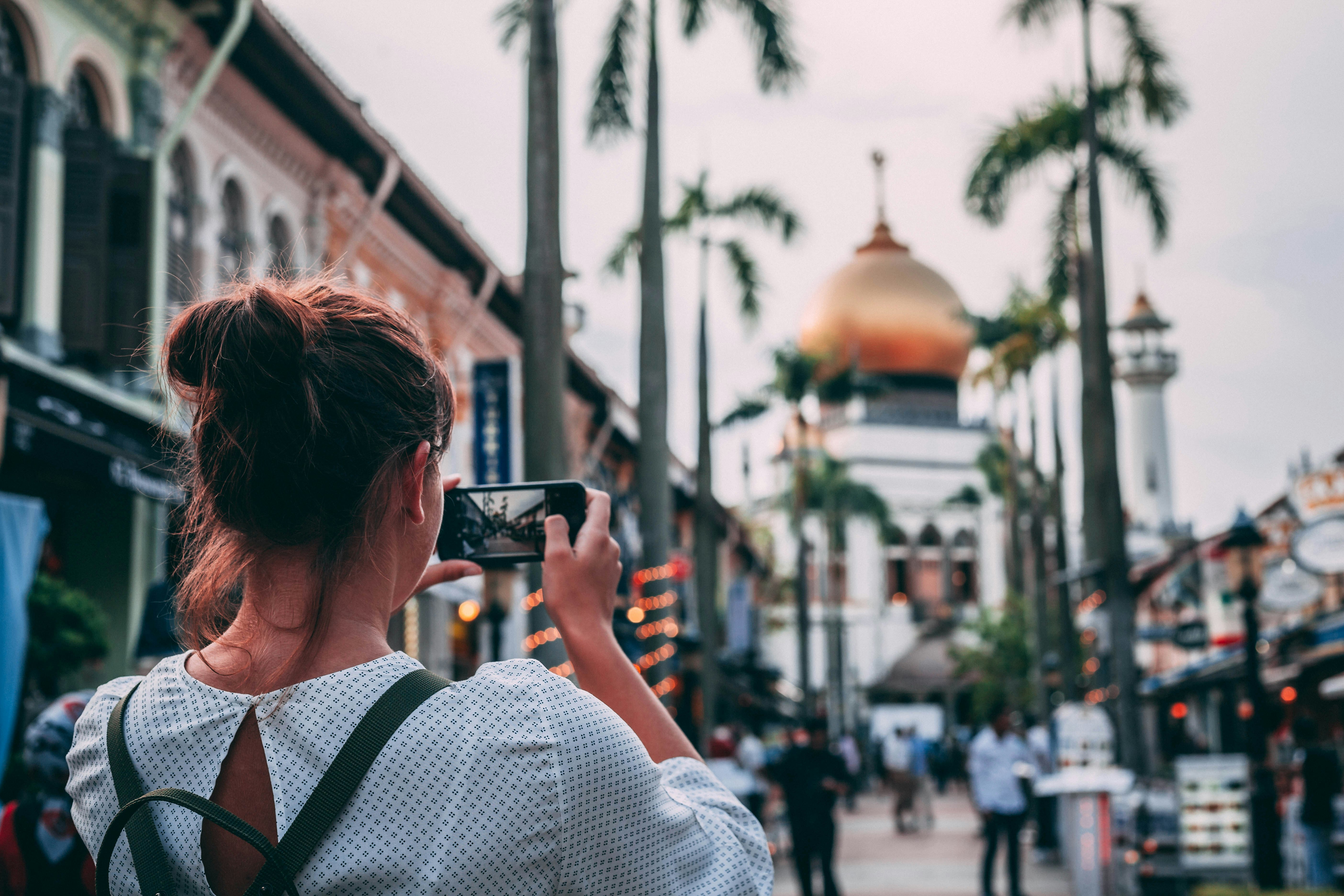 selective focus photography of woman taking photo